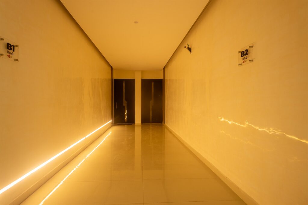 Brum Height 6: Warmly lit corridor with recessed linear lighting